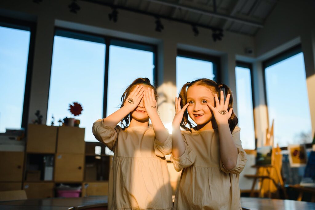 two twin girls posing in a sunlit classroom part of au pair program
