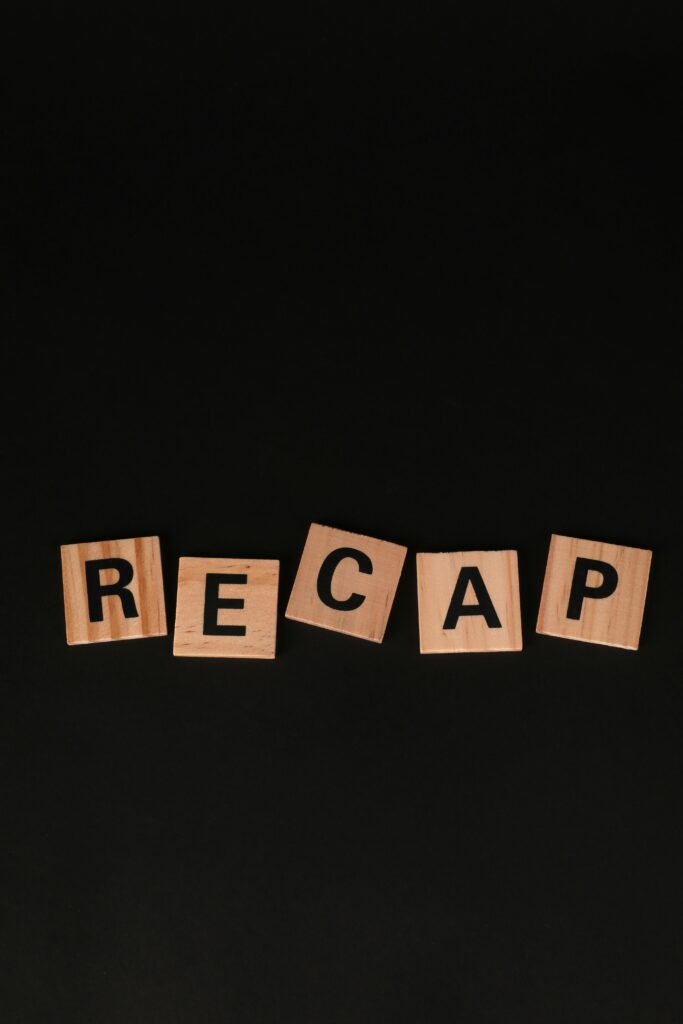 Scrabble-like wooden letter tiles forming the word 'RECAP' on a black background.