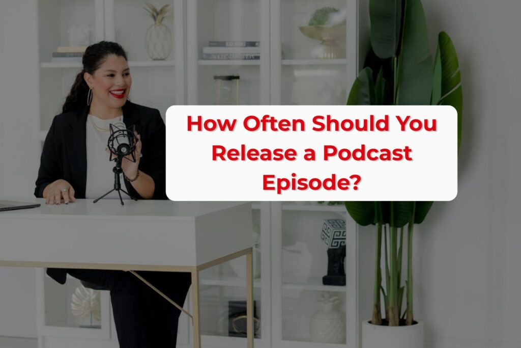 Heidy De La Cruz, a podcast coach for Latinas, sits at a desk with a laptop wearing a business suit. The photo accompanies the headline ‘How Often Should You Release a Podcast Episode?’